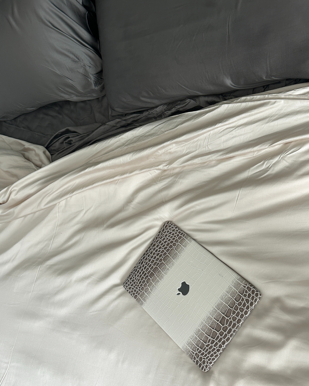 Laptop sitting atop of Cozy Earth's Bamboo Viscose Comforter (and sheet sets).