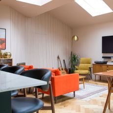 Open plan kitchen living space with colourful seating and textured panelled wall