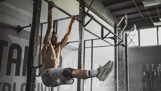 Best strength workout: person performing leg raises on a pull up bar