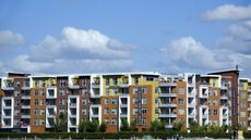 An apartment complex beneath a blue sky.