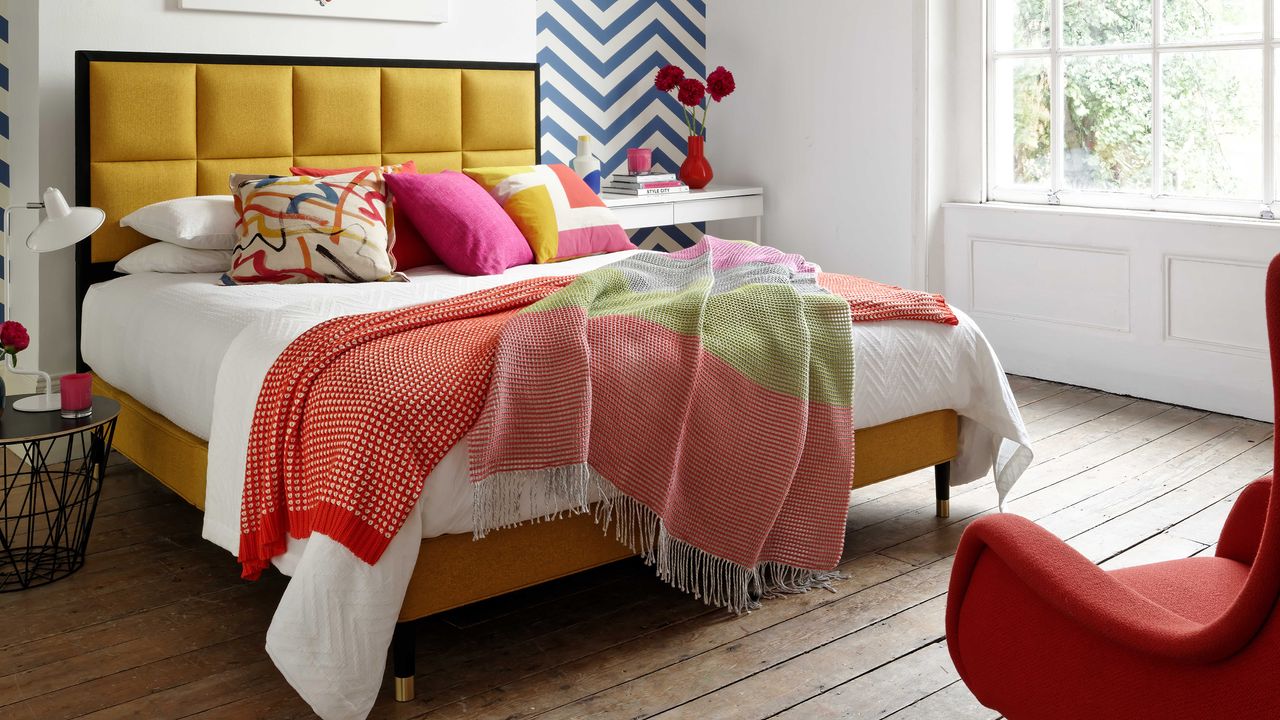 Bedroom with bed featuring upholstered yellow headboard