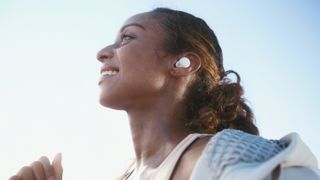 En kvinde løber med hvide Sony LinkBuds S i ørerne