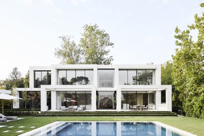 White villa with glass windows and a swimming pool