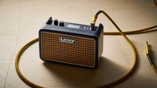 A Laney Prism Mini practice amp with a guitar cable plugged into it