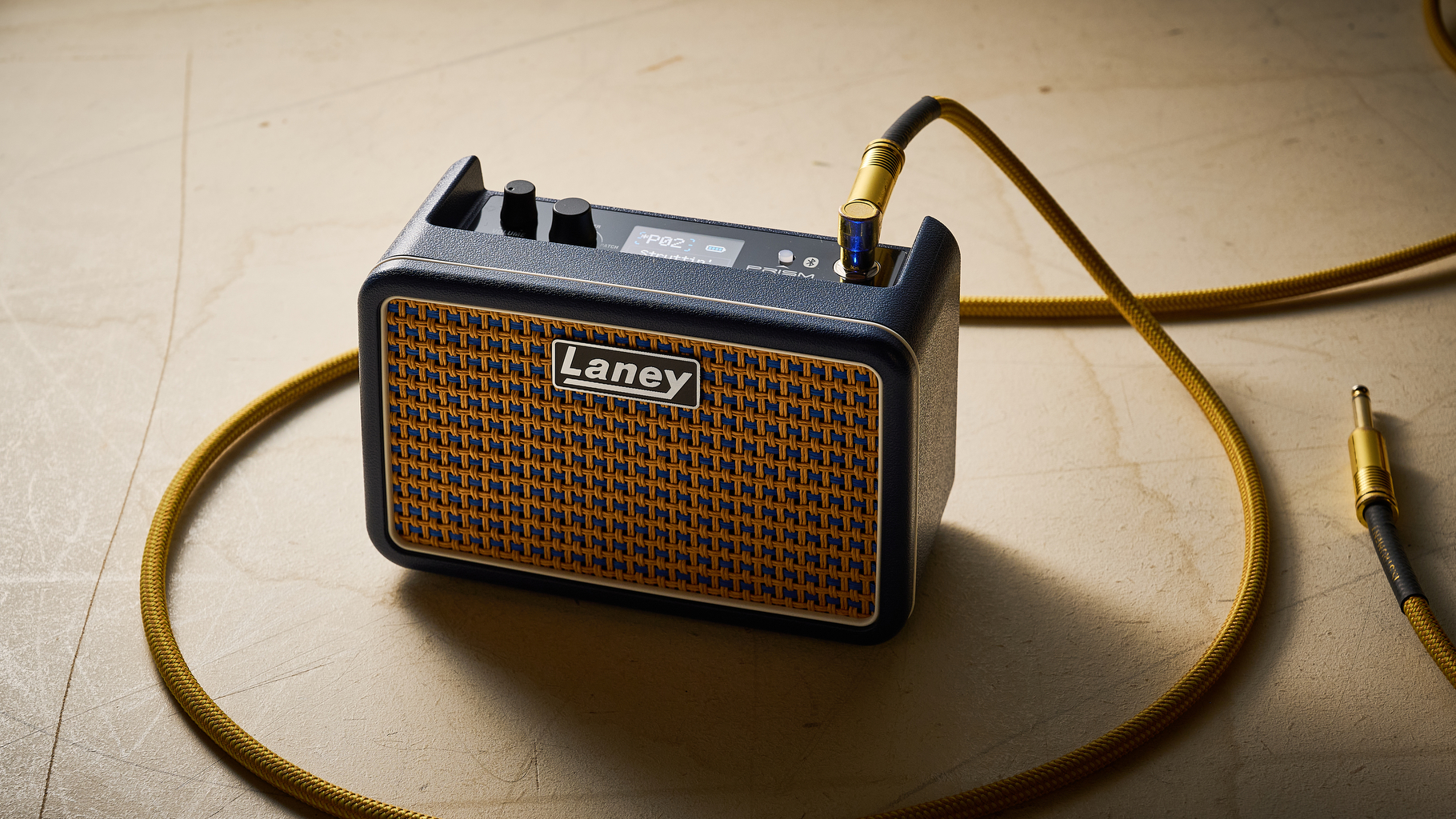 A Laney Prism Mini practice amp with a guitar cable plugged into it