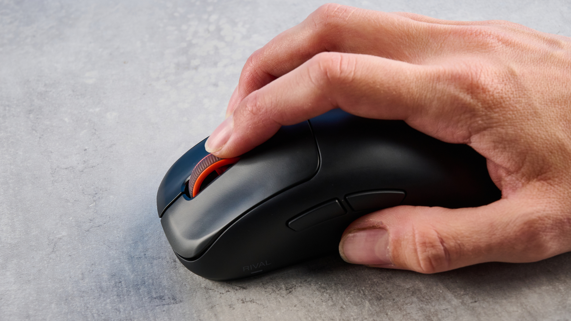 The SteelSeries Rival Pro mouse on a grey stone surface