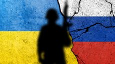 Shadow of soldier in front of flag of Ukraine and Russia painted on a brick wall