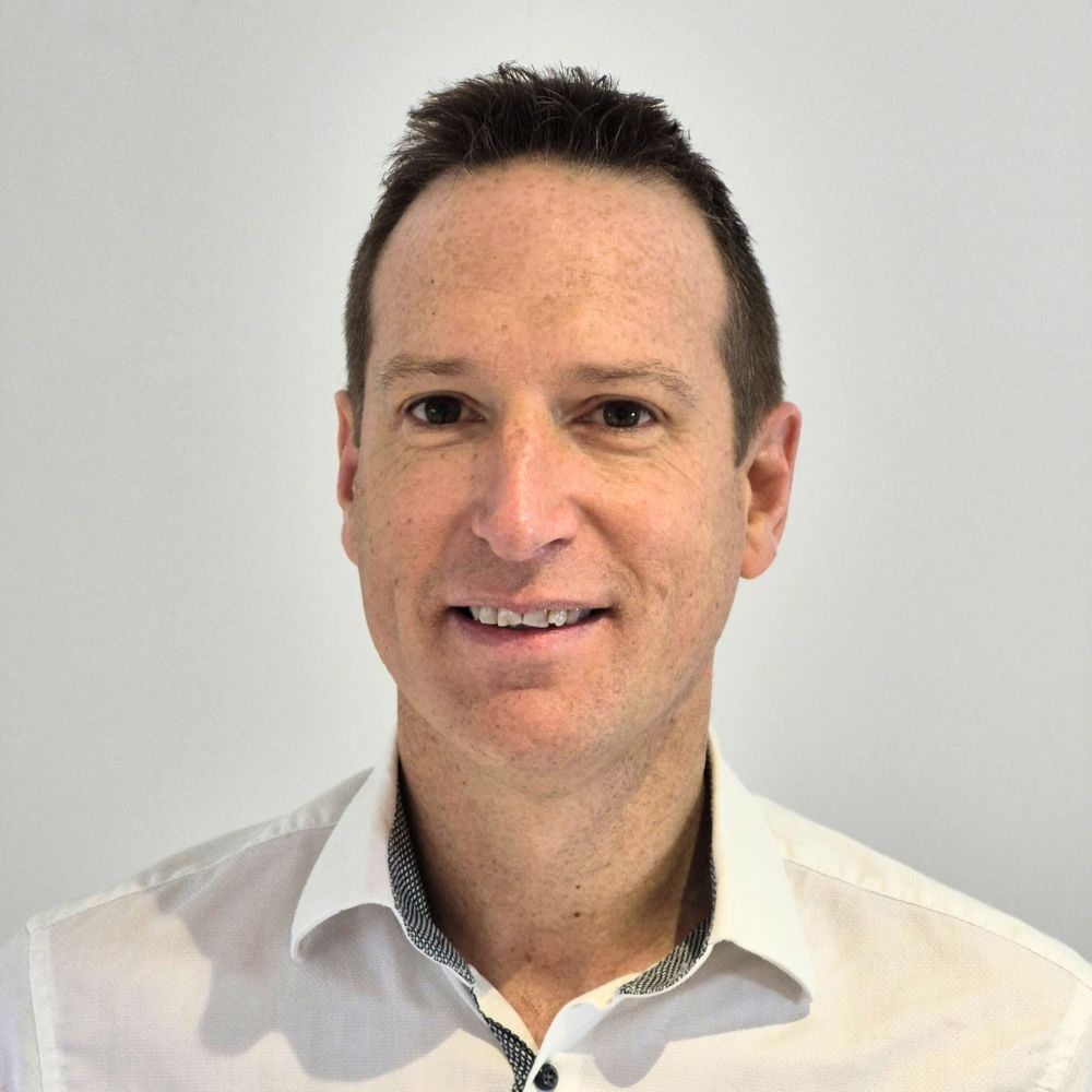 headshot of a smiling middle aged man on a white background