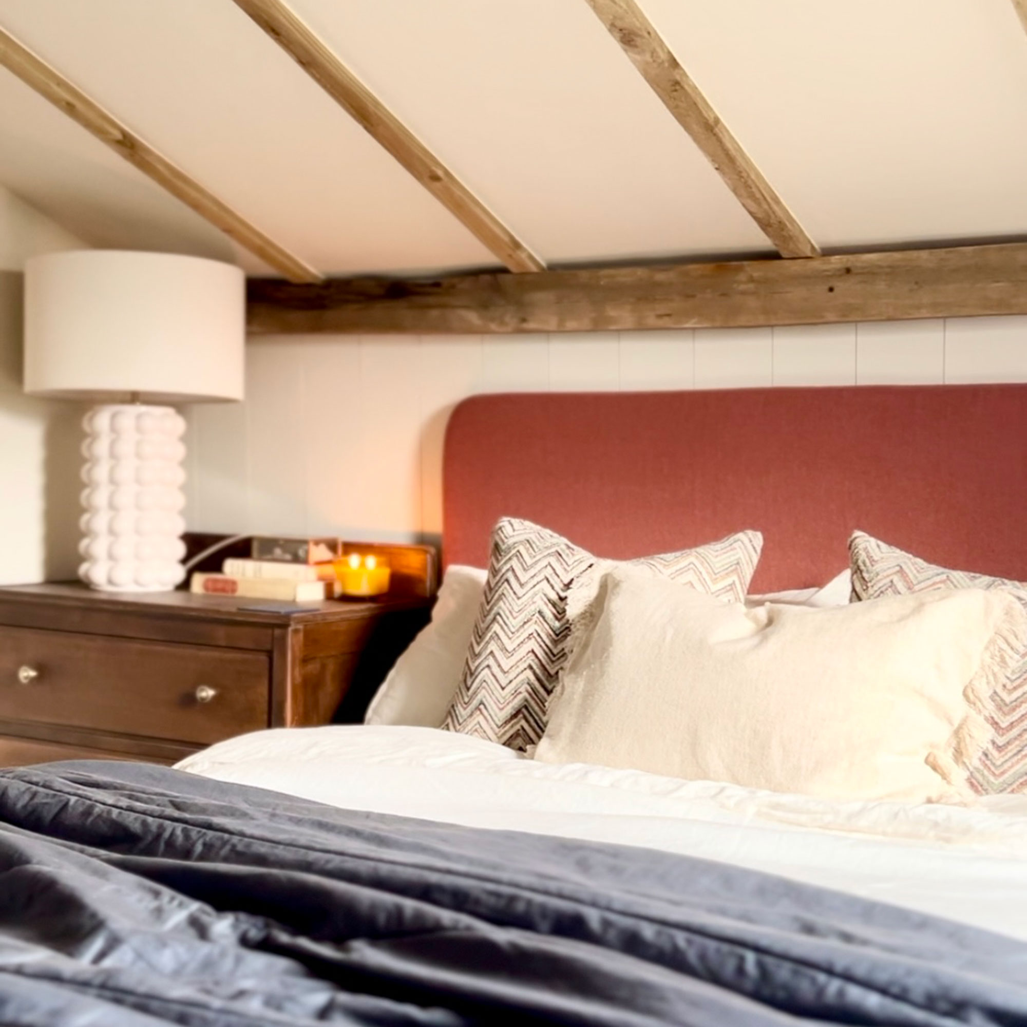 Bed under eaves ceiling with wooden beams