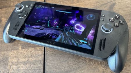 An Asus ROG Xbox Ally X on a wooden desk playing Halo: Campaign Evolved