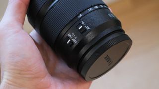 Panasonic Lumix S 28-200mm lens held in a hand