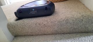 Black Robot Vacuum on a carpet