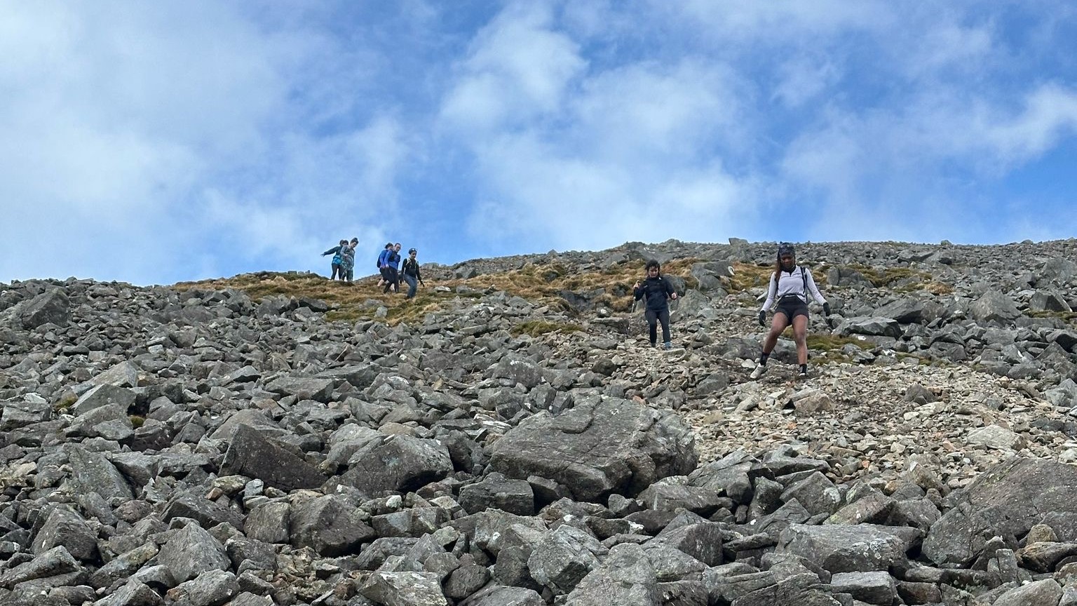 A group of women runners making their way down a scree slope