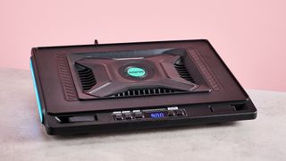 The Llano V10 Gaming Laptop Cooling Pad at a 3/4s angle with RGB lighting in front of a pink background.