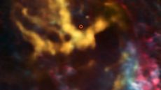 An image from the Atacama Large Millimeter/submillimeter Array (ALMA) shows molecular gas clouds around the region where the Milky Way's central, supermassive black hole is known to exist. That region, highlighted in red, looks dark and silent.