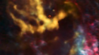 An image from the Atacama Large Millimeter/submillimeter Array (ALMA) shows molecular gas clouds around the region where the Milky Way's central, supermassive black hole is known to exist. That region, highlighted in red, looks dark and silent.