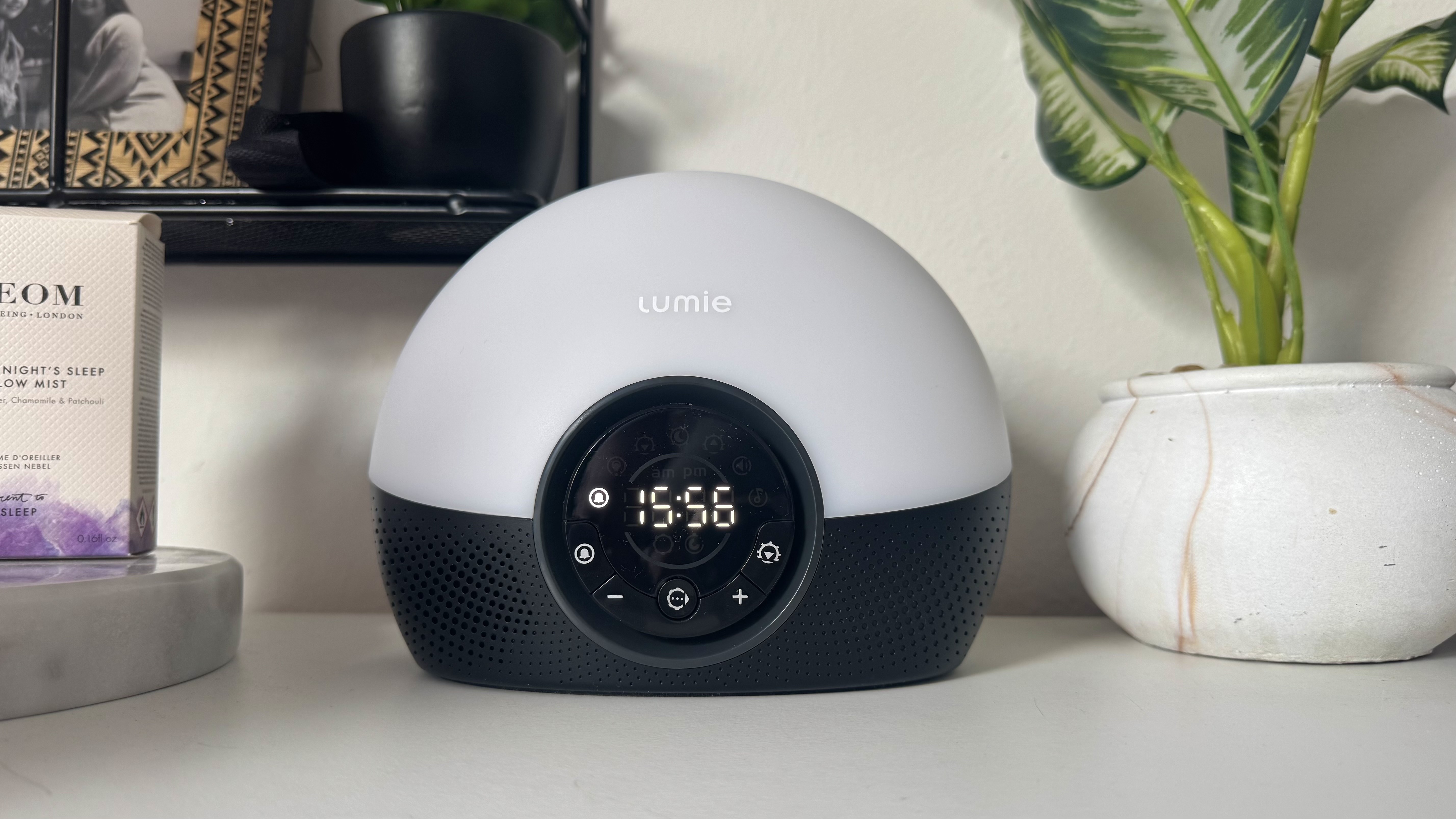 Lumie Bodyclock Glow 150 sunrise alarm clock on bedside table with NEOM pillow spray and plant