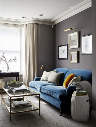 voile blinds paired with curtains in gray living room with blue sofa and gallery wall