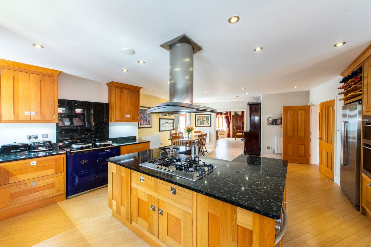 The kitchen island with induction hob and surrounding wooden cabinets