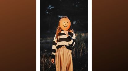 woman holding halloween jack o lantern balloon up to her face while outside