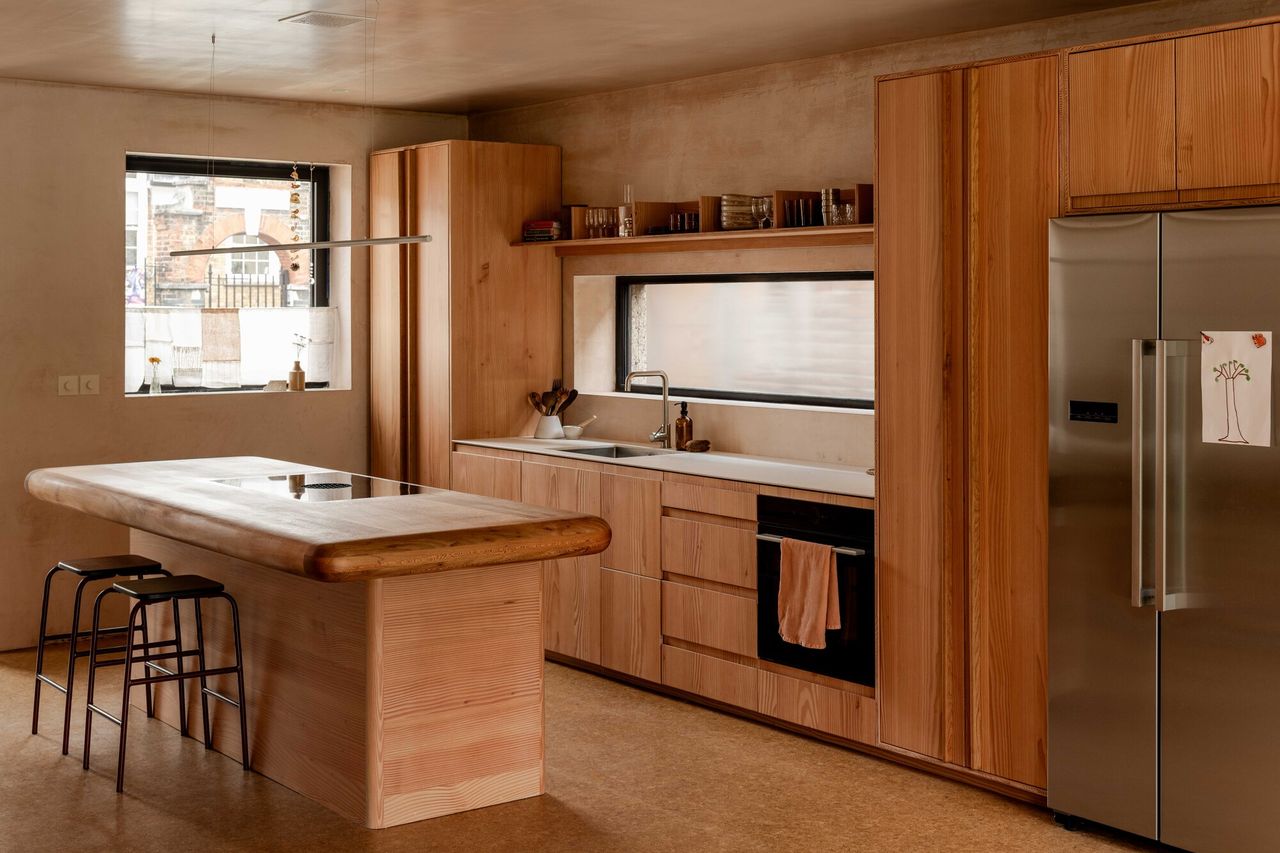 timber kitchen with cork flooring, timber cabinetry, reclaimed timber countertop, and two bar stools