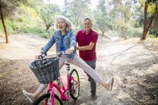 Husband pushing wife on a bike 