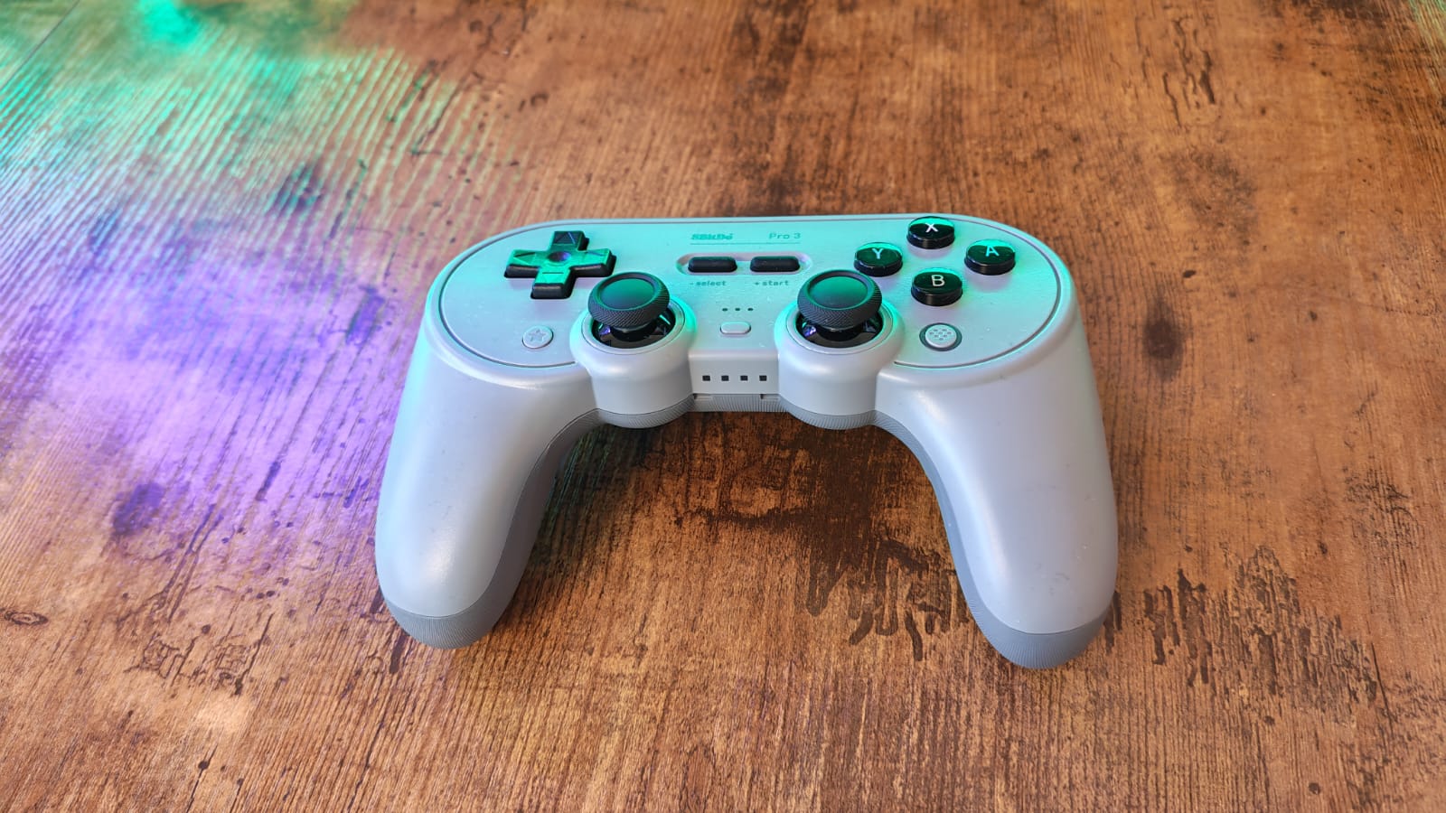 An 8BitDo Pro 3 controller on a wodden gaming desk