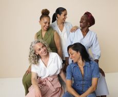 group of five women cheerfully looking at each other