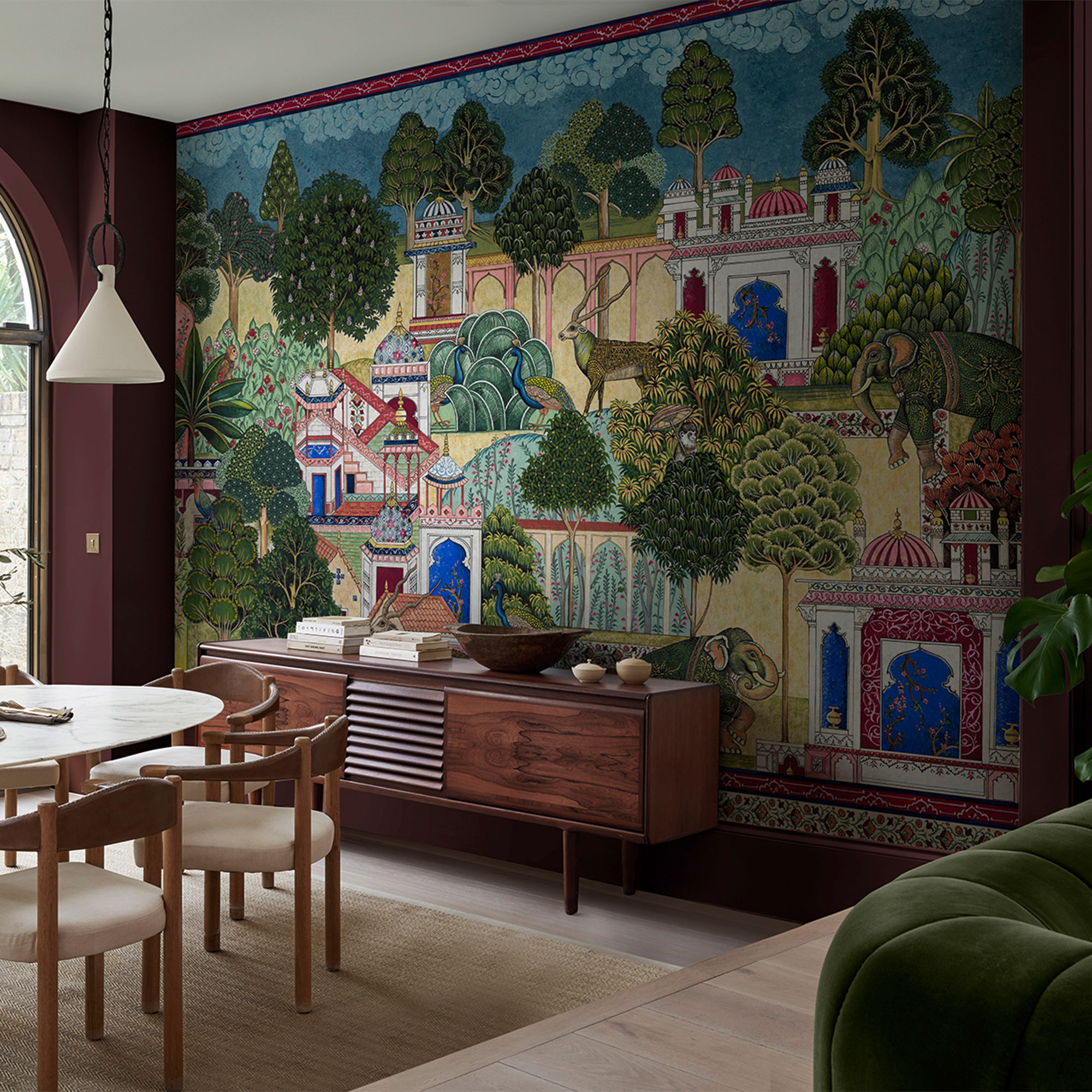Divine Damson red with the Eternal City mural on one wall with a wooden sideboard in front.