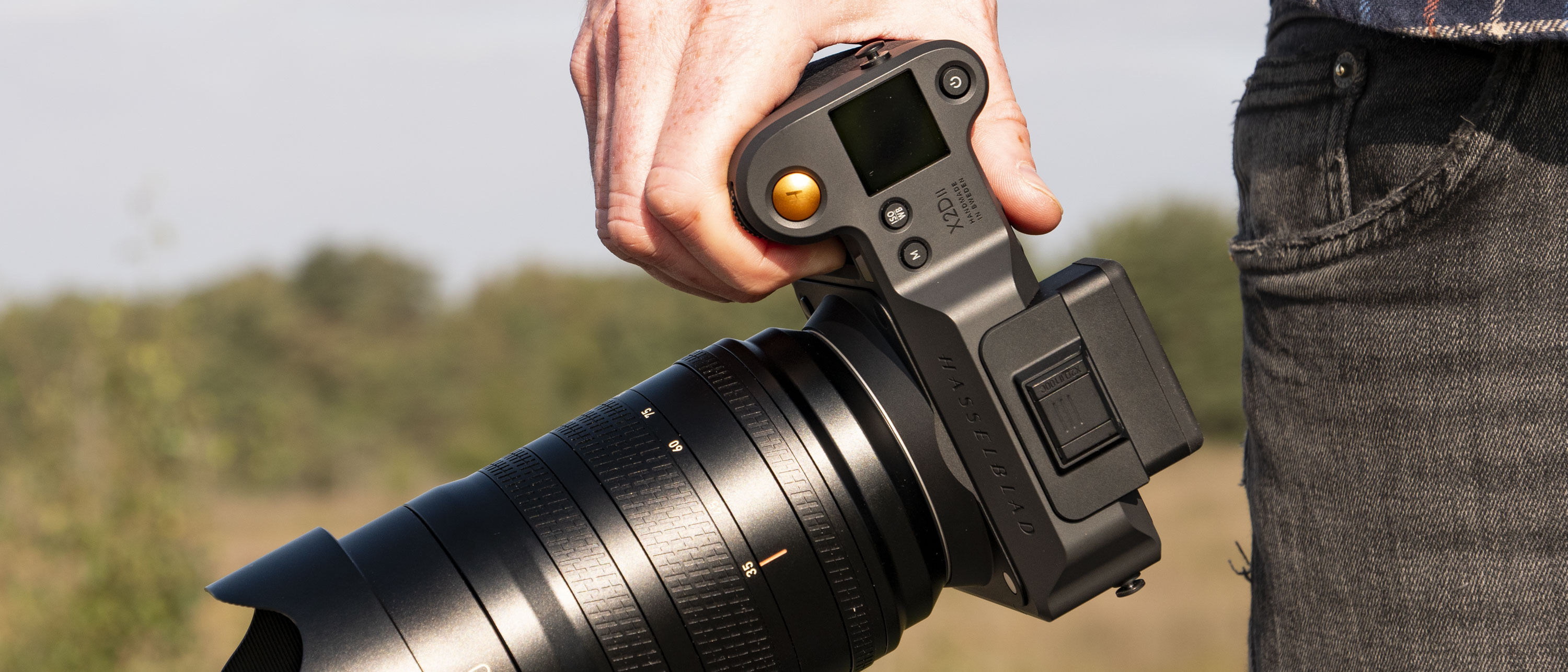 Hasselblad X2D II 100C camera in the hand, outdoors at first light