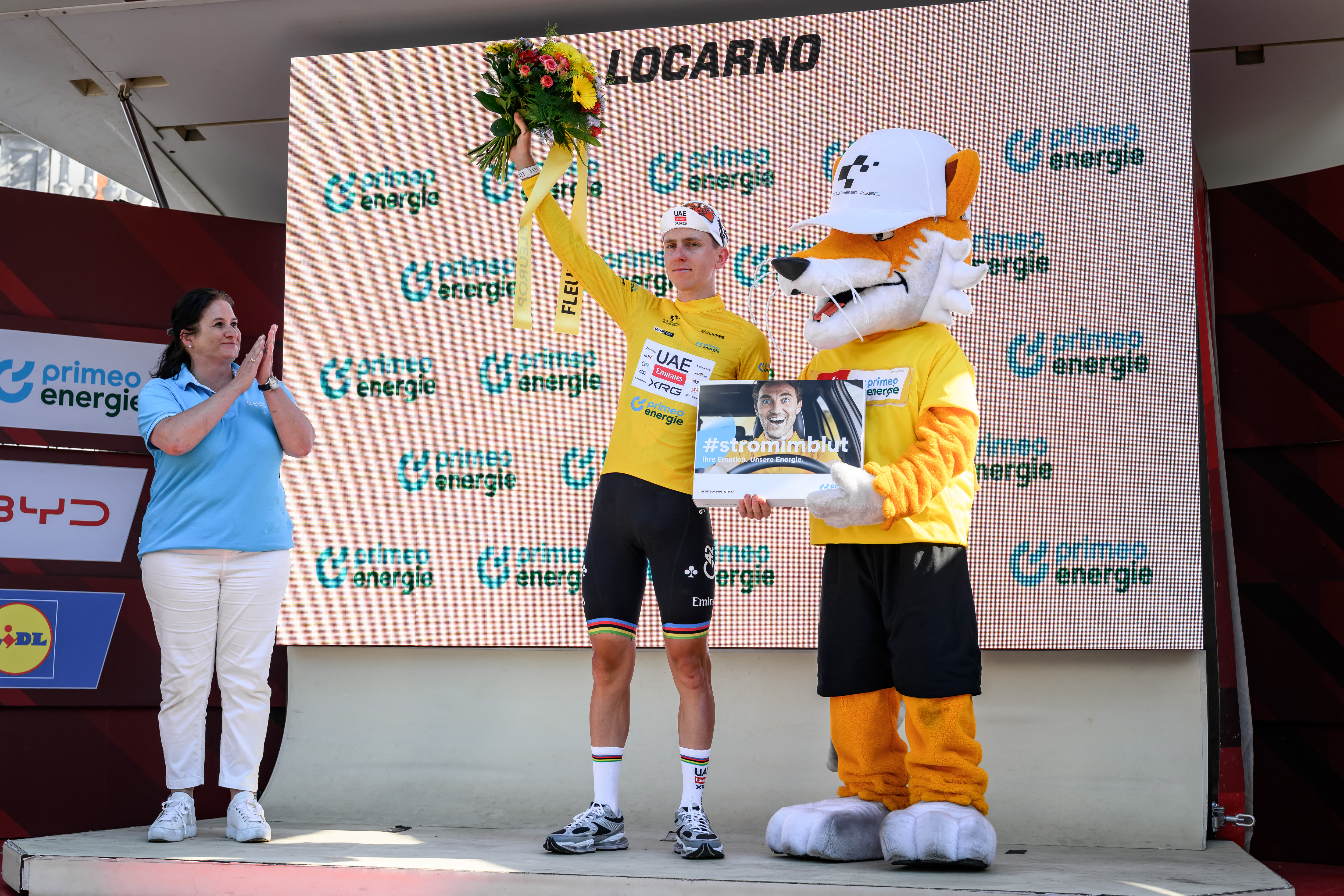 UAE Team Emirates-XRG's Slovenian rider Tadej Pogacar wearing the overall leader yellow jersey celebrates during the podium ceremony of the second stage 157,7km from Locarno to Locarno at the Men's Tour of Switzerland (Tour de Suisse) cycling race in Locarno, Switzerland, on June 18, 2026. (Photo by Fabrice COFFRINI / AFP via Getty Images)