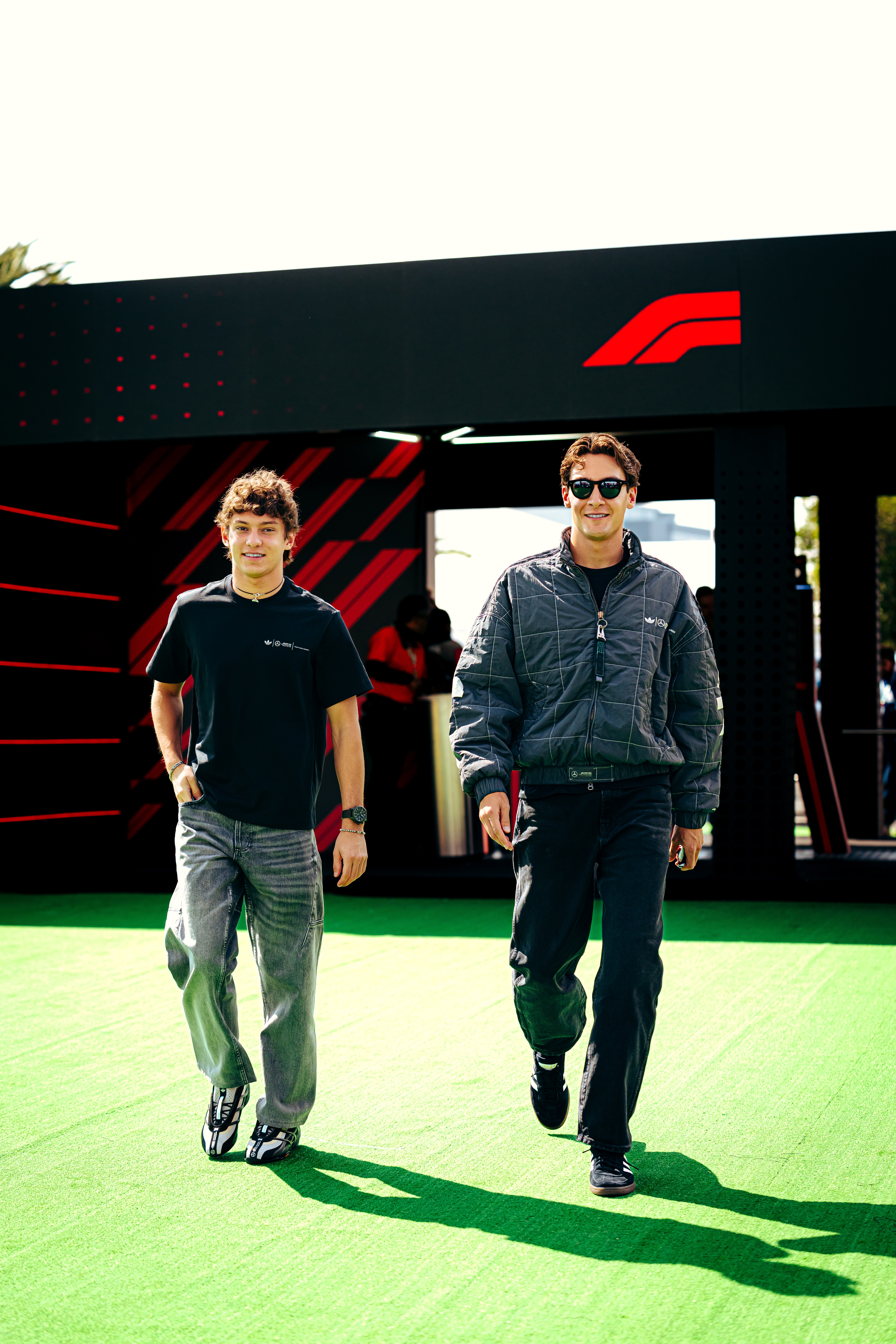 Kimi Antonelli and George Russell wearing the Adidas x Bad Bunny x Mercedes collection in the F1 paddock.
