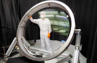 A person stands inside a lens from the observatory