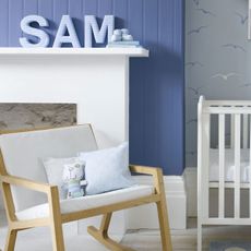 Blue and white back Nursery with white and wood rocking chair