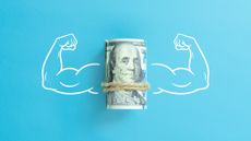 Flexed muscular arms on either side of a roll of cash.