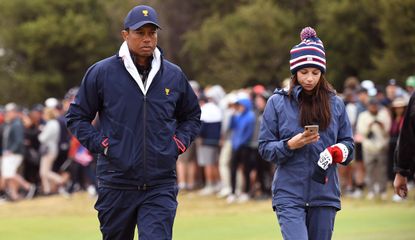 Tiger Woods and Erica Herman walk the fairway during the Presidents Cup