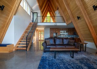 generous, double height living space at Lake Placid A-Frame by Strand Design