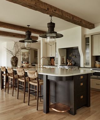 Colonial home kitchen with a black island and warm neutral cabinetry