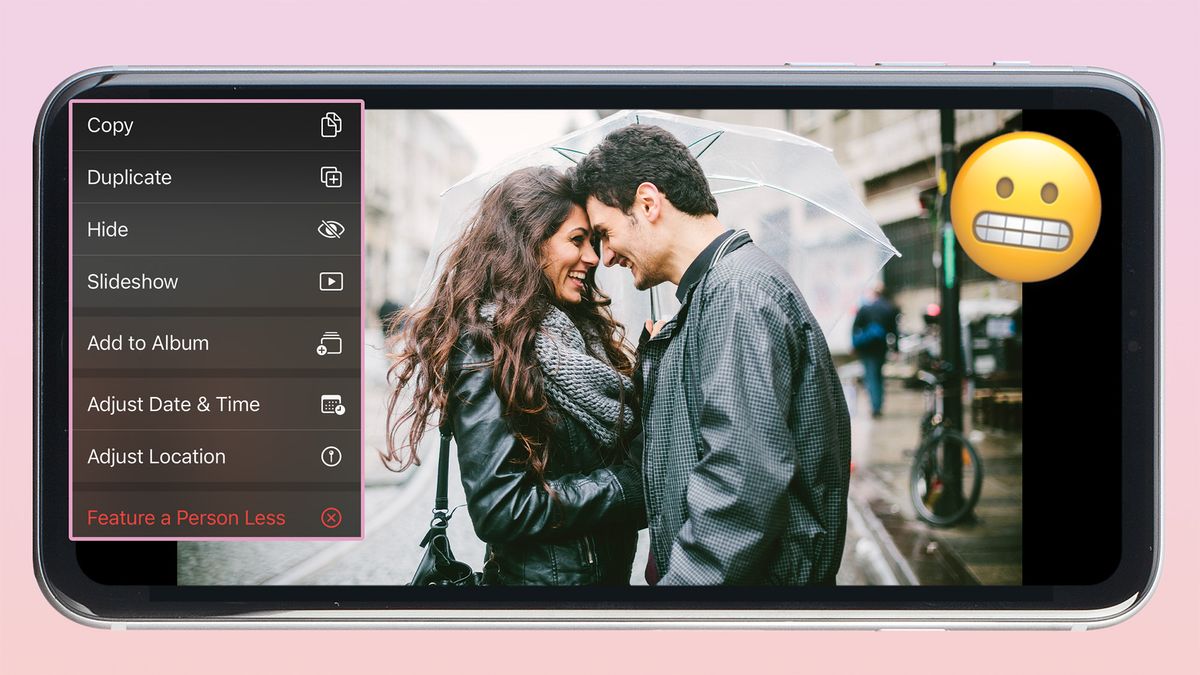 Photo of woman and man embracing beneath umbrella on a smartphone screen, with an inset image of the Photos app&#039;s drown-down menu with a Grimacing Face emoji 