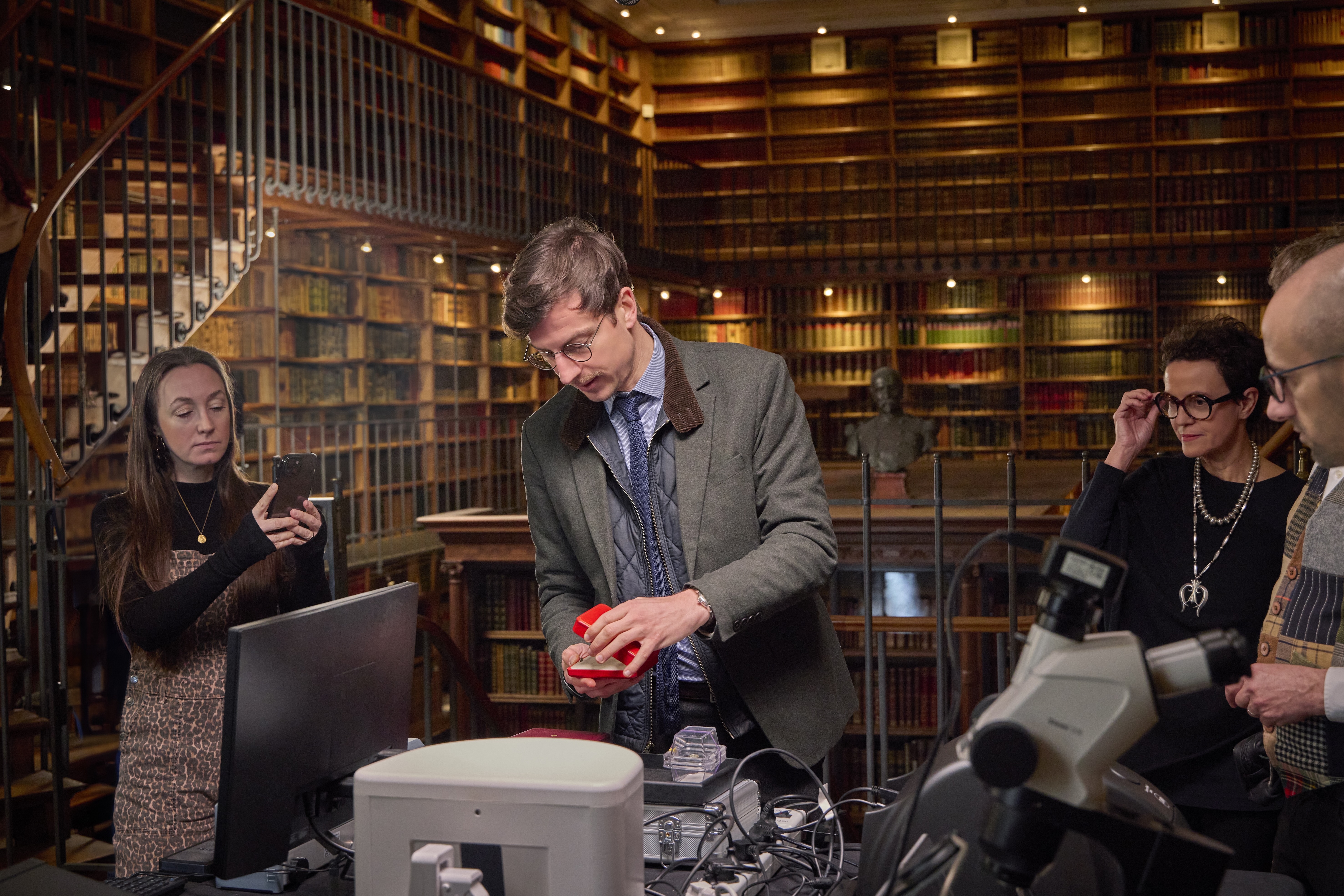 A group of gemologists analysing a pink diamond