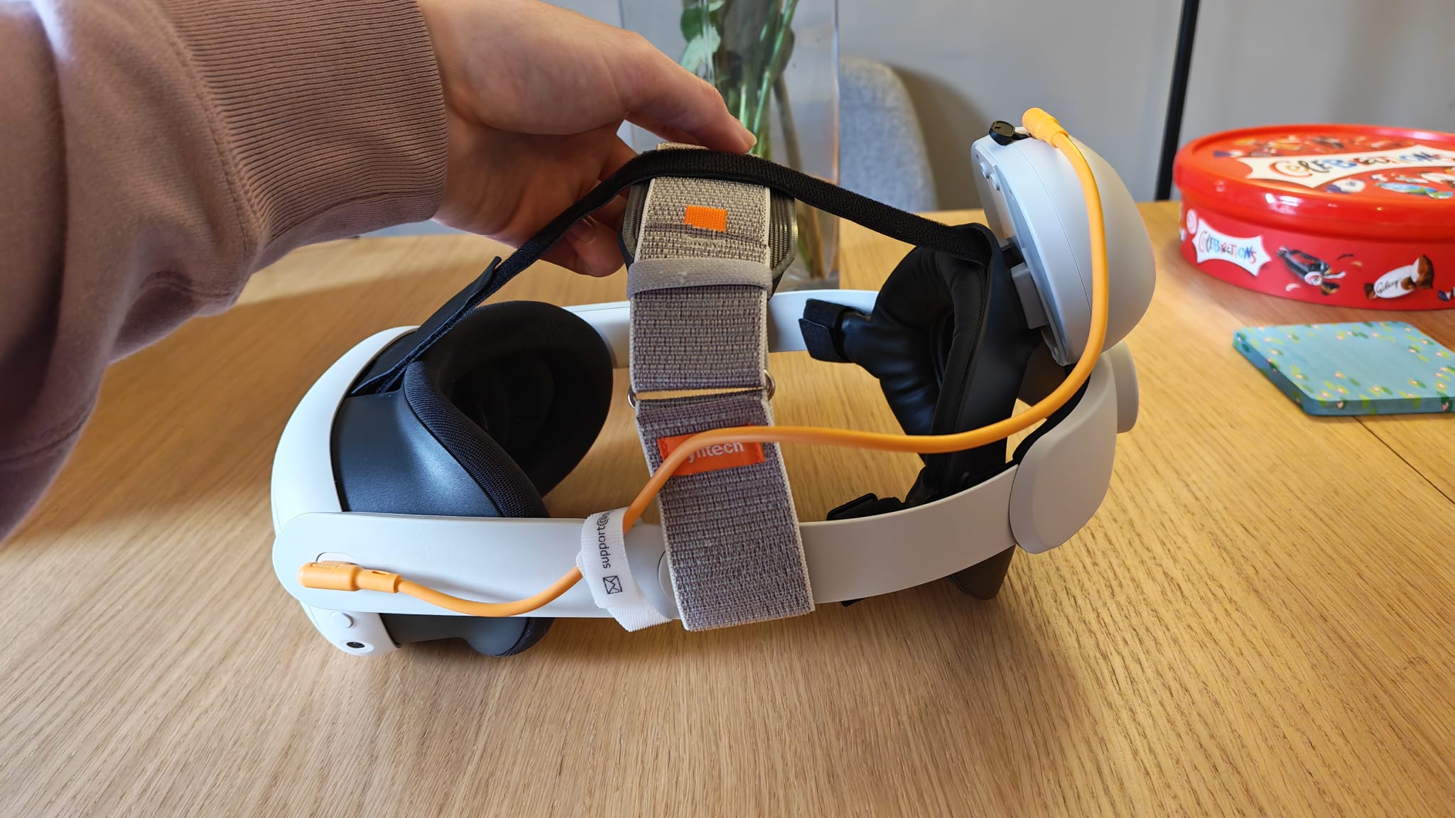 A reviewer showing the two strap system on the Syntech Elite Head Strap for Quest 3