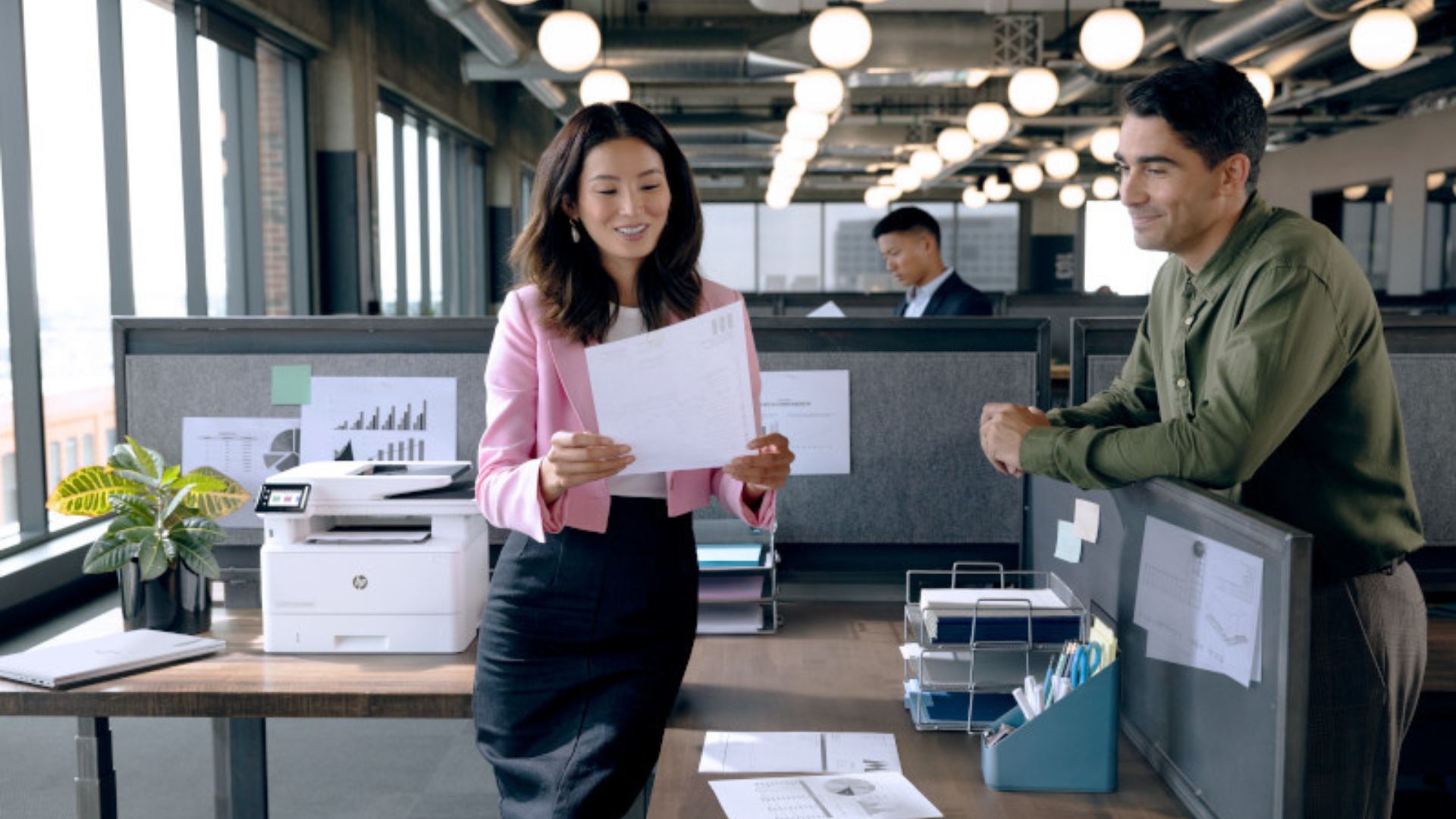 Two co-workers examining the quality of printed copies next to the HP LaserJet Pro 4101fdw