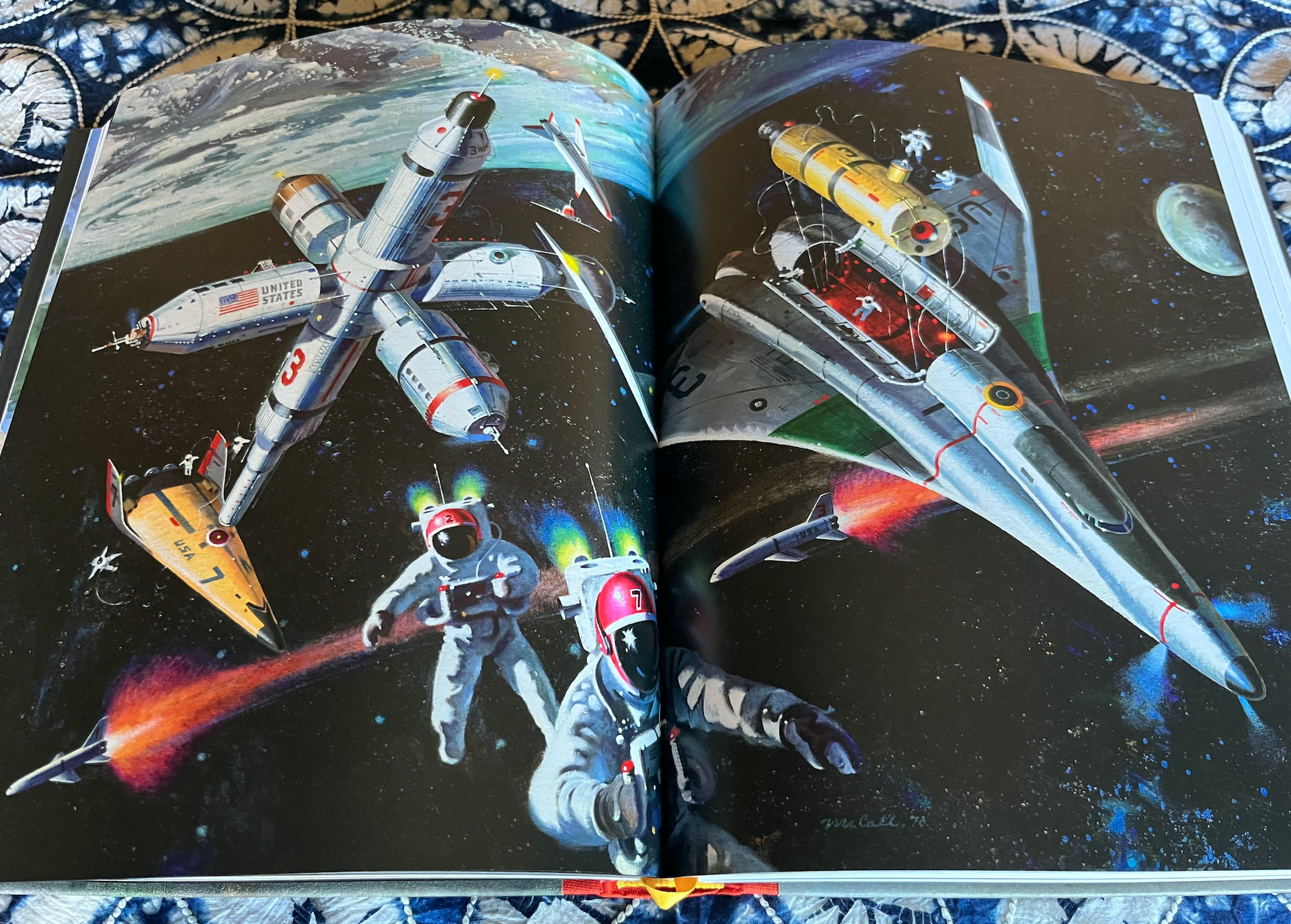 an open book with pages depicting space art