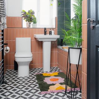 terracotta bathroom with patterned floor tiles and brown wall tiles