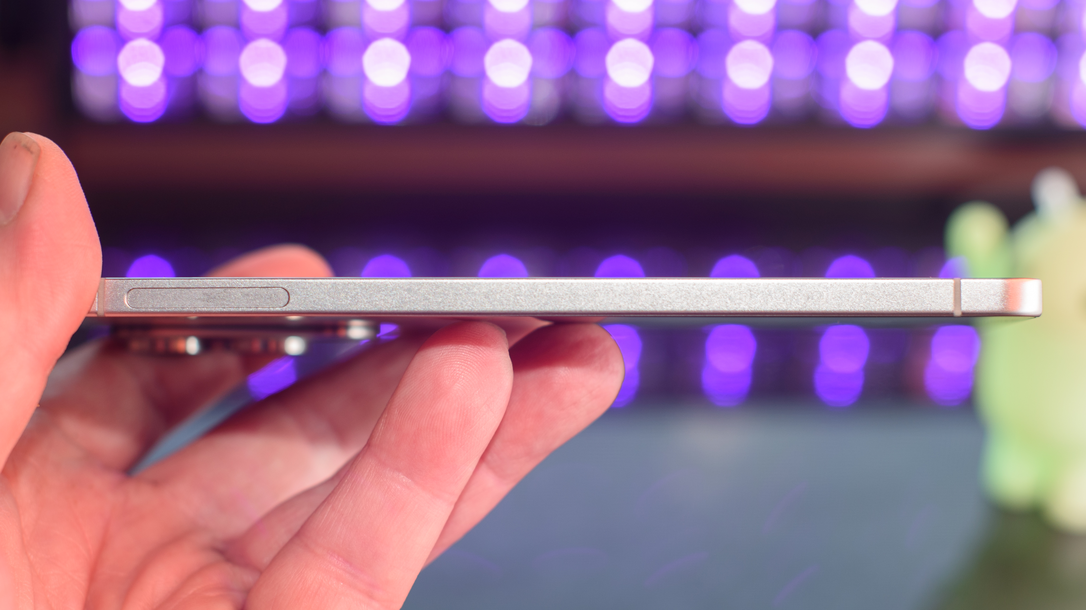 Samsung Galaxy S25 Edge from the side with black lights blurred in the background