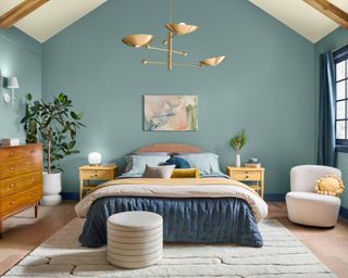 bedroom with blue walls, high sloped ceiling and cozy decor