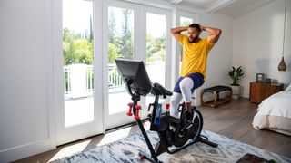 Men exericing with the Bowflex VeloCore Bike in his living room