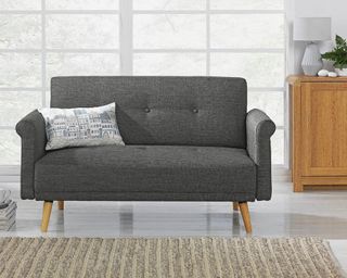 Grey Argos sofa in front of glass windows in white living room with beige rug