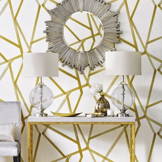 hallway with entrance table infront of white and gold geometric wallpaper