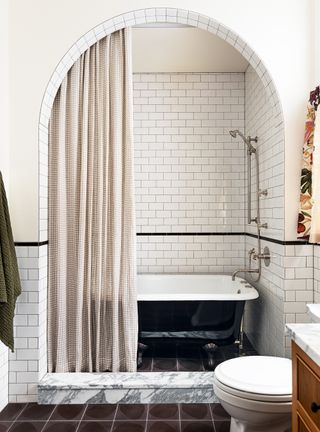 Small bathroom with arched door frame and white metro tiles